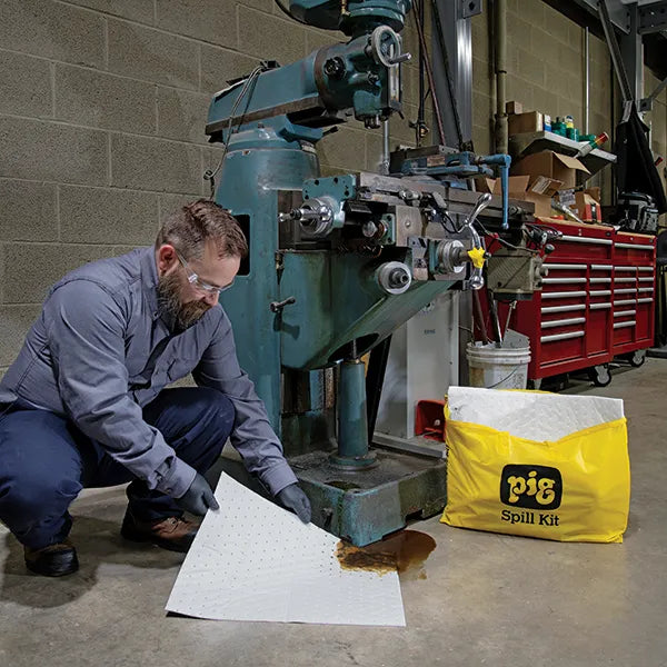 Gelekte olie bij machine wordt opgeruimd met spill kit van absorptieshop