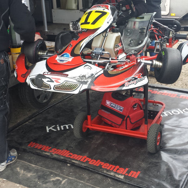 kart die op een lekmat staat in de paddock om olie en brandstof op te vangen, te koop bij absorptieshop
