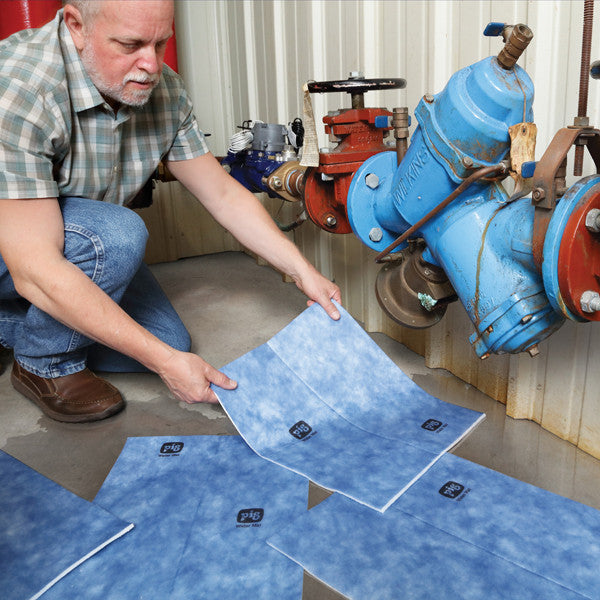 Waterabsorberende doeken in gebruik bij een middelgrote lekkage bij buizen in een fabriek – voorkomt verspreiding van water en minimaliseert schade